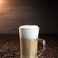 Objektfoto von Latte Macchiato der auf Kaffeebohnen steht